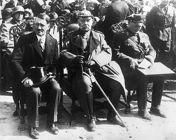 Agosto de 1933: Recém eleito como chanceler Adolf Hitler (1889 - 1945), Presidente Paul Von Hindenburg (1847 - 1934) e o minsitro Hermann Goering (1893 - 1946) assistindo a comemoração da vitória sobre as forças Russas de 1914 - Foto: Getty Images