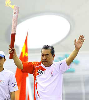 Filho do 1º atleta olímpico chinês carrega tocha