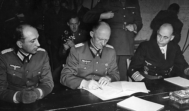 General Alfred Jodl (1890 - 1946) conselheiro militar de Hitler, assina o documento de rendição (capitulação alemã) das forças armadas alemãs em Reims. Ele é acompanhado pelo Major Wilhelm Oxenius (esquerda) e Georg Hans von Friedeburg, o almirante da Frota (direita) - foto: Getty Images